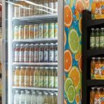 Supermarket yoʻlagida rangli plyonka va topperli brendlangan muzlatgich